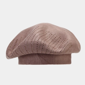 Détail du béret tricoté rose poudré avec des motifs ondulés en strass brillants