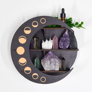 Detail of dark grey crescent moon wooden shelf with golden lunar phase decor
