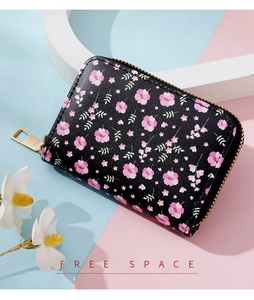Detail view of floral print card holder with golden zipper on a colorful background