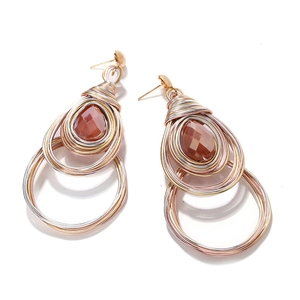 Detail of bohemian wire-wrapped heart earrings with brown gemstone on white background