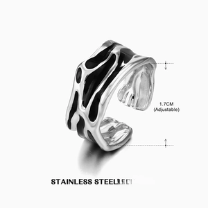 Macro view of adjustable stainless steel ring with black enamel and liquid texture