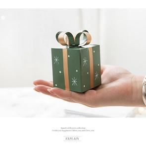 Mini green Christmas gift box ornament with white snowflakes and a gold bow detail