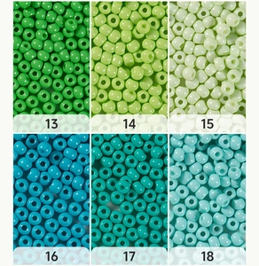 Macro detail of 4mm glass seed beads in six shades of green and peacock blue for DIY jewelry