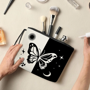 Black and white butterfly makeup bag with sun and moon prints being held by hands