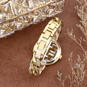 Close-up of gold iced-out hip hop watch with diamond chain on luxury brown background