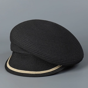 Detailed close-up of a black woven straw sun hat with contrast gold stitched brim edge