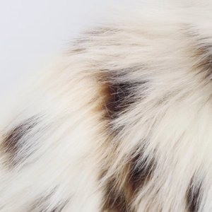 Macro close-up showing soft cream and brown faux fur texture with glossy finish