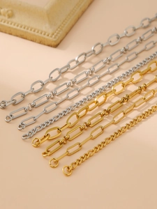 Detail view of 18k gold and silver stainless steel chain bracelets with polished textures