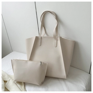 Detail view of large cream PU leather tote bag with a matching small zipper pouch