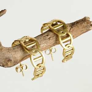 Detailed close-up of 18K gold plated C-hoop chain link earrings on a natural branch