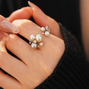 Macro shot of layered pearl ring with sparkling zircon accents on model hand