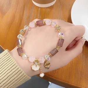 Pink strawberry quartz beaded bracelet with starfish charms and pearls on a woman's wrist