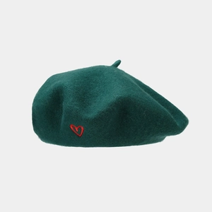Close-up of wool-blend dark green beret with a small red embroidered heart detail