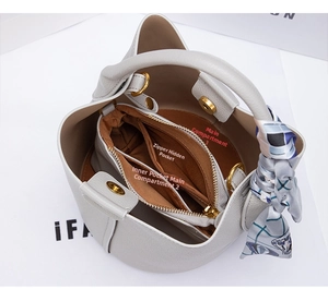 Interior view of leather bucket bag showing compartments, zipper pocket and silk scarf handle