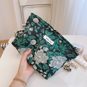 Macro detail of floral jacquard fabric pouch with zipper and simple wish label