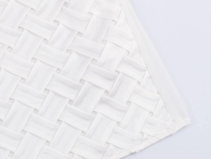 Gros plan sur la texture du tissu tissé blanc avec motifs diagonaux du chemisier en satin