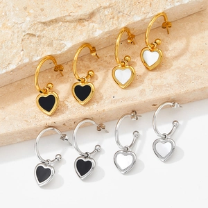 Luxurious heart-shaped shell hoop earrings in gold and silver on stone steps