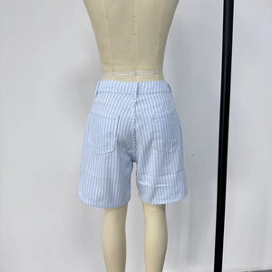 Detail view of light blue vertical striped denim shorts with high waist and five-pocket design