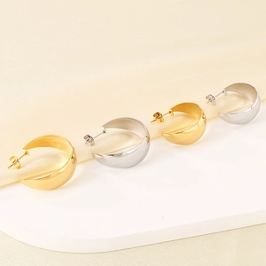 Polished C-shape stainless steel earrings in gold and silver finish on silk