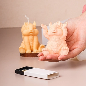 Cute handmade squirrel-shaped scented candles in pink and yellow on wooden bases