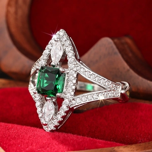 Macro detail of silver ring with emerald-cut green stone and marquise-cut accents