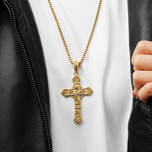 Close-up of gold hip-hop cross necklace with intricate relief on a male model