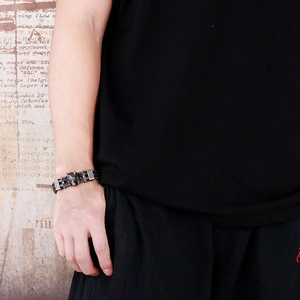 Detail of punk style wolf head bracelet in gunmetal finish on a male wrist