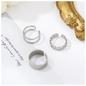 Detailed view of three-piece silver ring set including chain texture and smooth bands