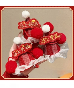 Close-up of red sequined Christmas hat hair clips with festive gold embroidery and white lace
