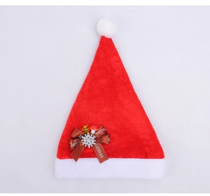 Detail of red plush Christmas hat featuring a brown ribbon bow and snowflake ornament