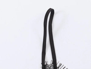 Détail de la dentelle délicate et des fines bretelles sur un haut en satin noir