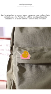 Gros plan d'un pin's en émail patate mignonne sur une poche de sac à dos en toile verte