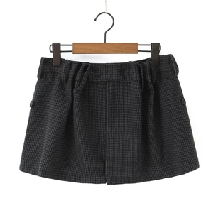 Close-up of high-waist plaid mini skirt with double button detail and wool texture