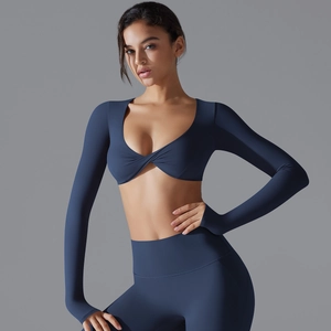 Dettaglio del set yoga blu scuro con crop top a maniche lunghe e leggings