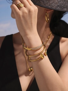 Détail de l'ensemble de bijoux plaqué or 18K avec joncs, bagues et boucles d'oreilles