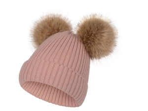 Détail du bonnet en maille côtelée rose avec deux grands pompons en fausse fourrure