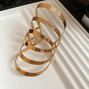 Irregular multilayer gold metal arm cuff featuring hammered, brushed, and mirrored textures