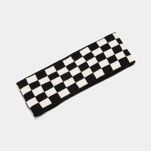 Detail of black and white checkered knitted headband with elastic fabric texture