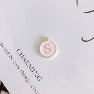 Detailed view of round pink enamel letter S pendant for DIY necklace accessories