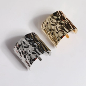 Detailed macro view of gold and silver hair accessories with unique hammered metal texture