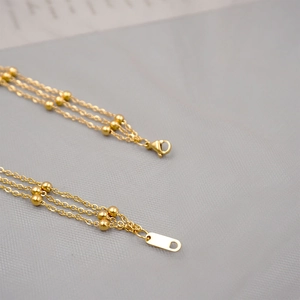 Three-layer gold titanium steel chain necklace with small beads and rectangle tag