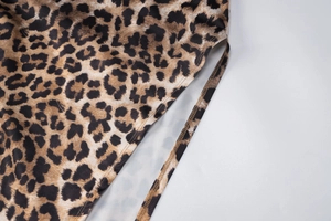 Dettaglio macro dell'abito in chiffon leopardato con cuciture e spacco laterale rifinito