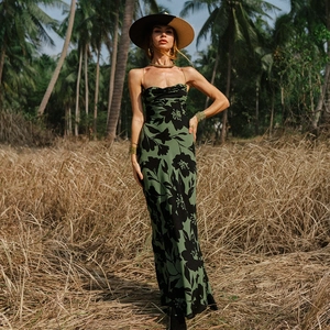 Detailed view of long green satin dress with black floral print and thin straps