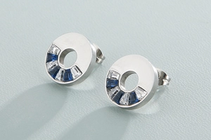 Detailed close-up of geometric hoop earrings with blue and white trapezoid zircon stones