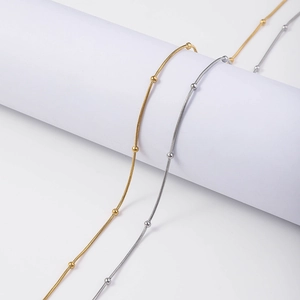 Detailed view of 18K gold and silver snake bone chains with delicate bead accents