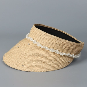 Close-up of woven straw sun hat with elegant pearl trim and sparkling rhinestone accents