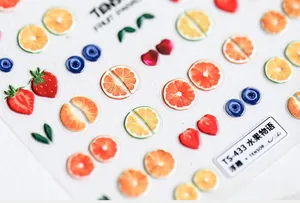 Gros plan d'autocollants 5D pour ongles aux motifs de fraises et d'oranges sur carte