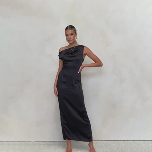 Detailed view of the sleek black satin fabric and slim fit design of the strapless maxi dress