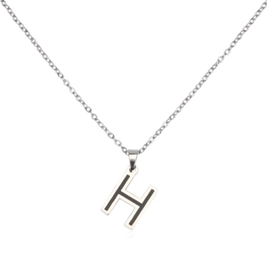 Macro detail of H-letter pendant necklace with silver finish and black enamel inlay