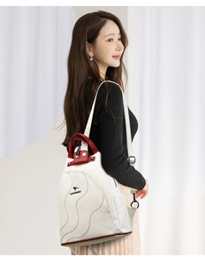 Model wearing a white and red leather backpack with a branded metal logo detail